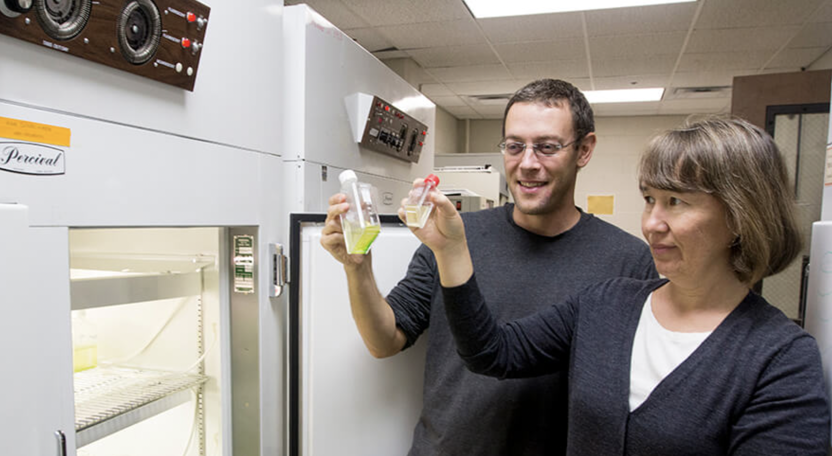 Christopher Klausmeier and Elena Lichtman examine bottles in a lab