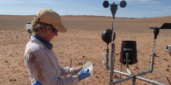 Sarah Evans deploys petri dishes at a weather station to study what kind of microbes are present in the air.